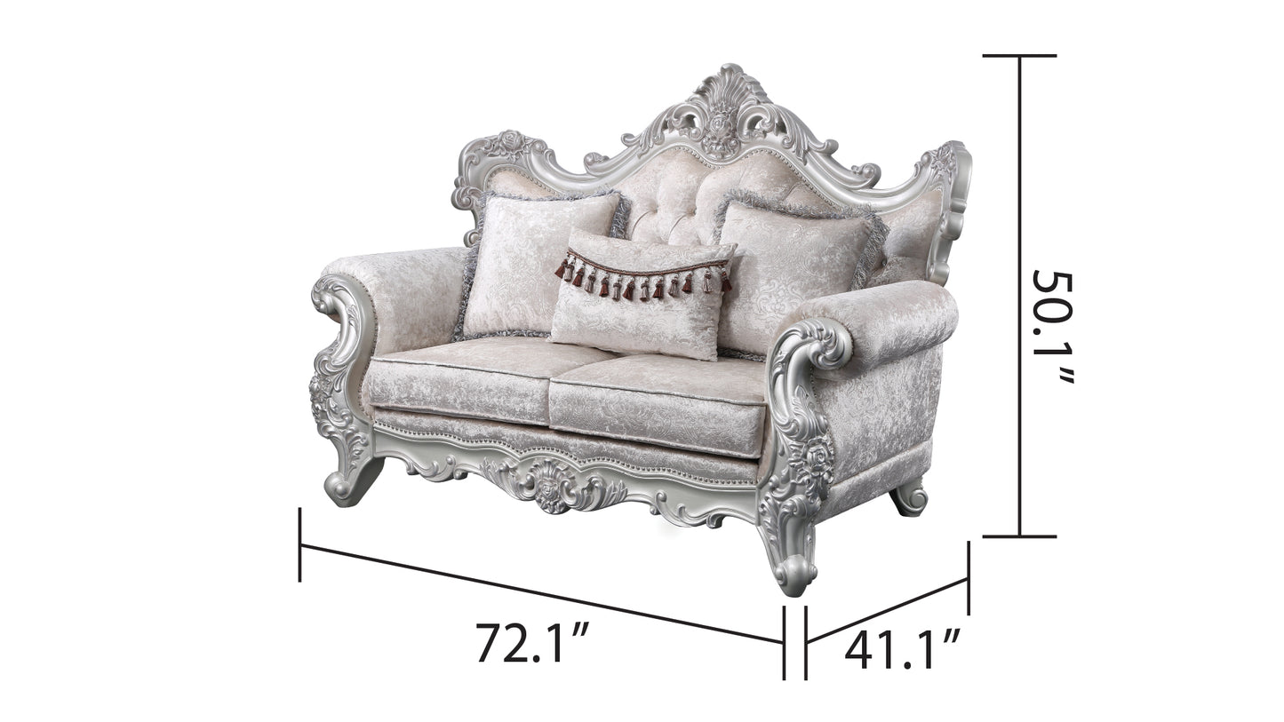 Ornate silver carved sofa with plush ivory velvet upholstery and decorative tassels