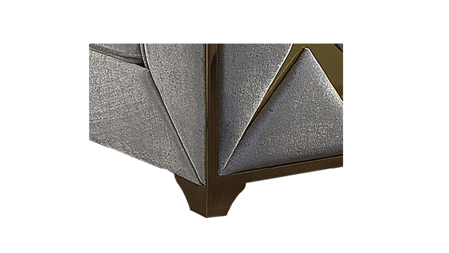 Closeup of textured silver geometric paneling with bronze trim on a furniture leg