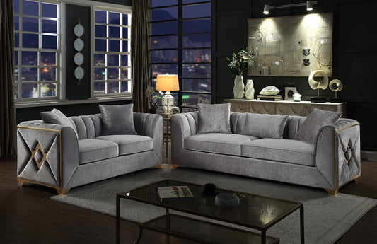 Luxurious grey velvet sofa with gold trim and patterned throw pillows
