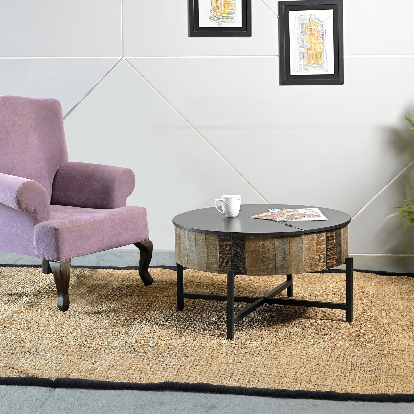 Round reclaimed wood coffee table with dark gray top and black metal base in a living room setting