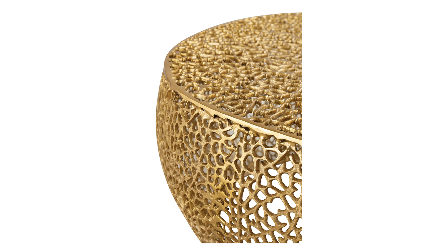 Closeup of a round gold metal coffee table with an intricate porous lattice design