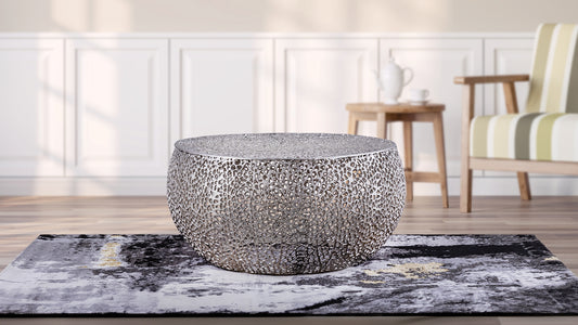 Round silver metal coffee table with intricate cutout design modern living room accent piece