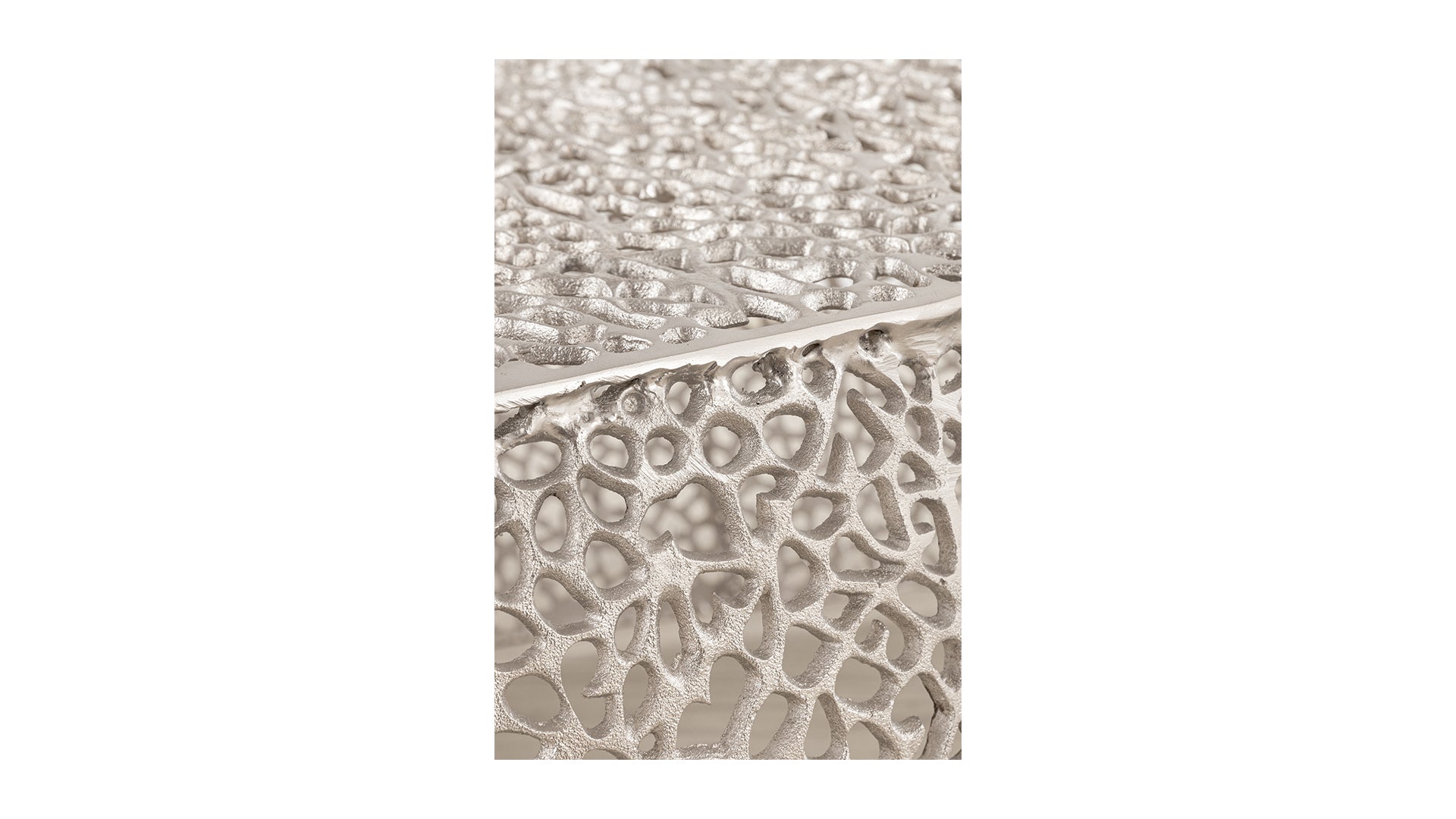 Textured silver side table with organic porous design