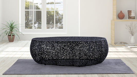 Black oval coffee table with intricate cutout design on gray rug