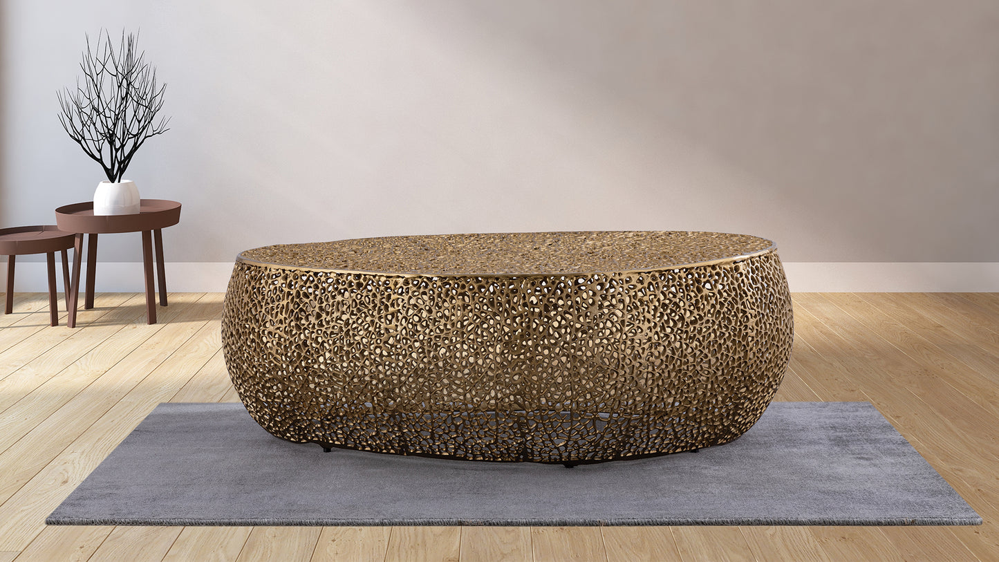Ornate brass coffee table with openwork design on gray rug
