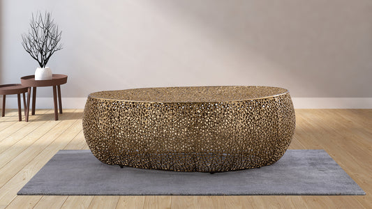 Ornate brass coffee table with openwork design on gray rug