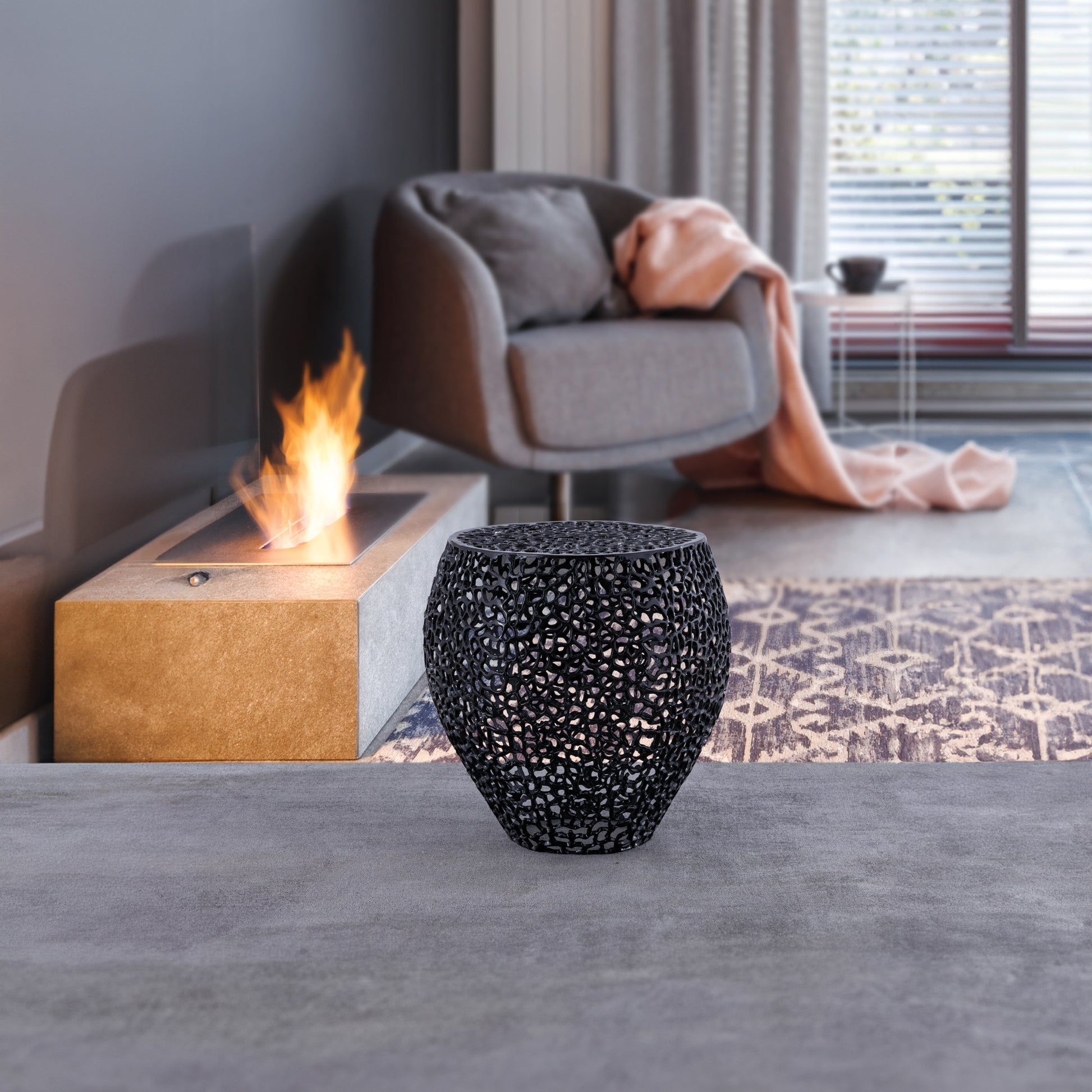 Decorative black metal side table with intricate cutouts and a geometric design