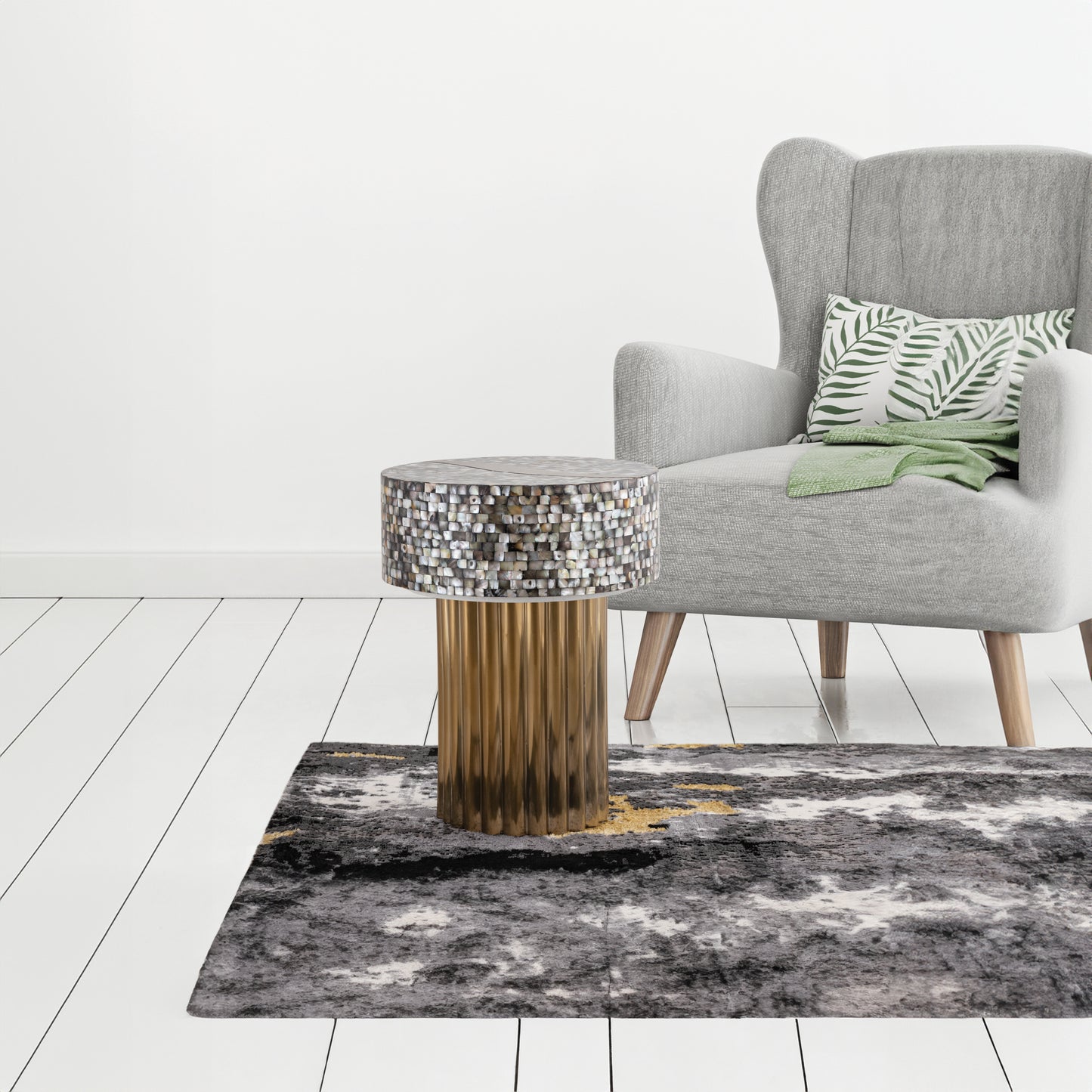 Grey armchair with palm leaf pillow and green throw next to mosaic accent table