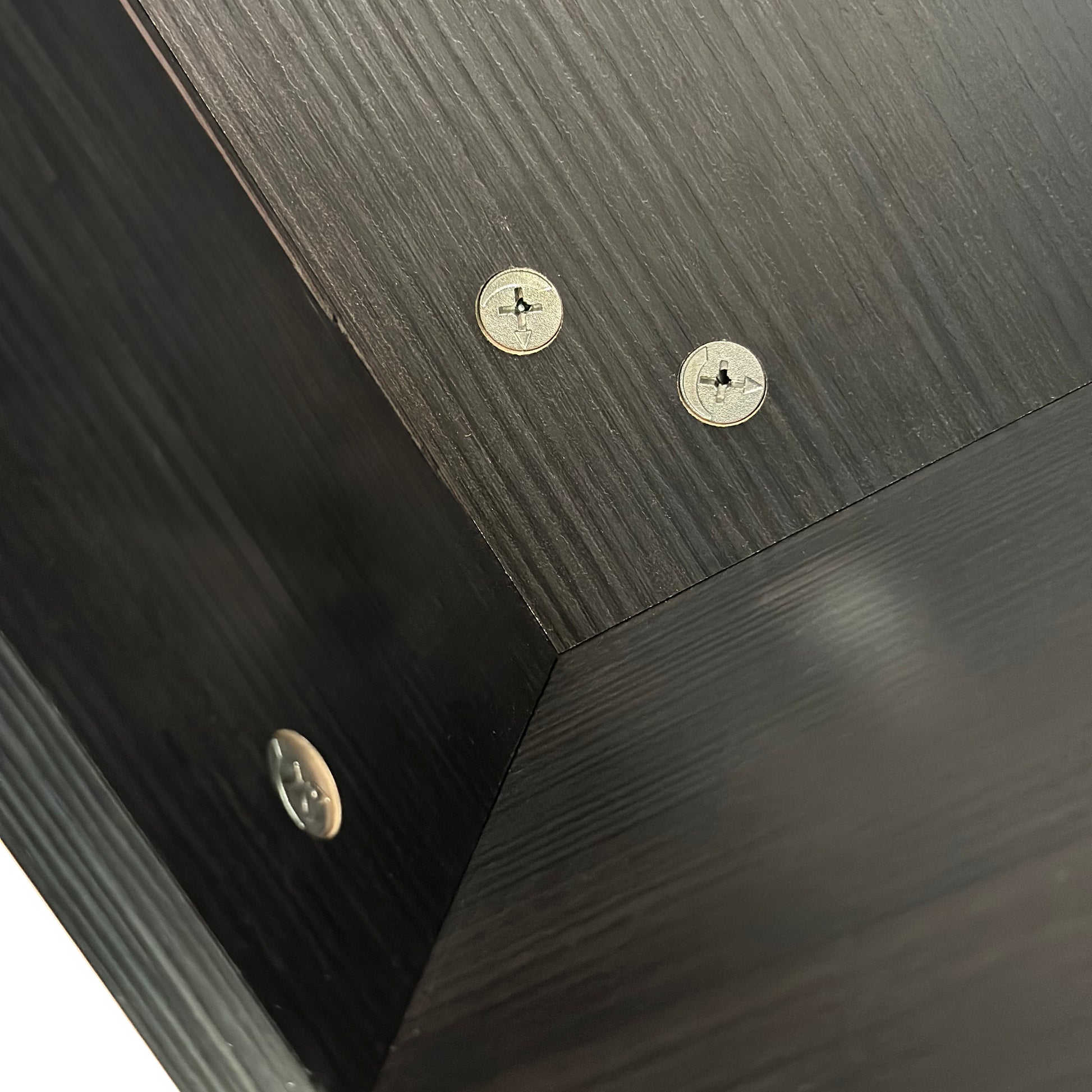 Dark wood grain finish on furniture panel with visible screw fasteners