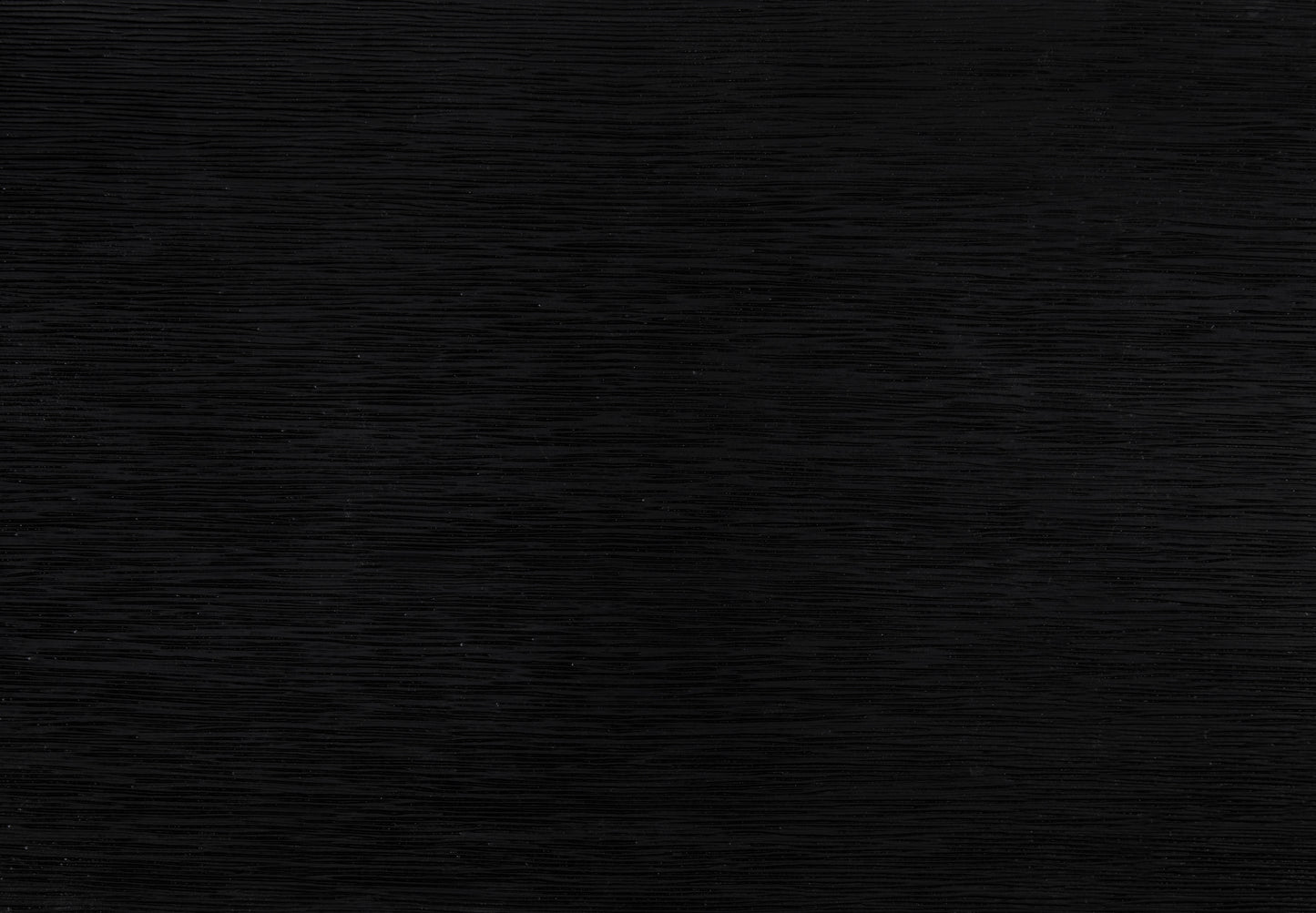 Closeup of a textured black wood veneer sample showcasing its horizontal grain pattern