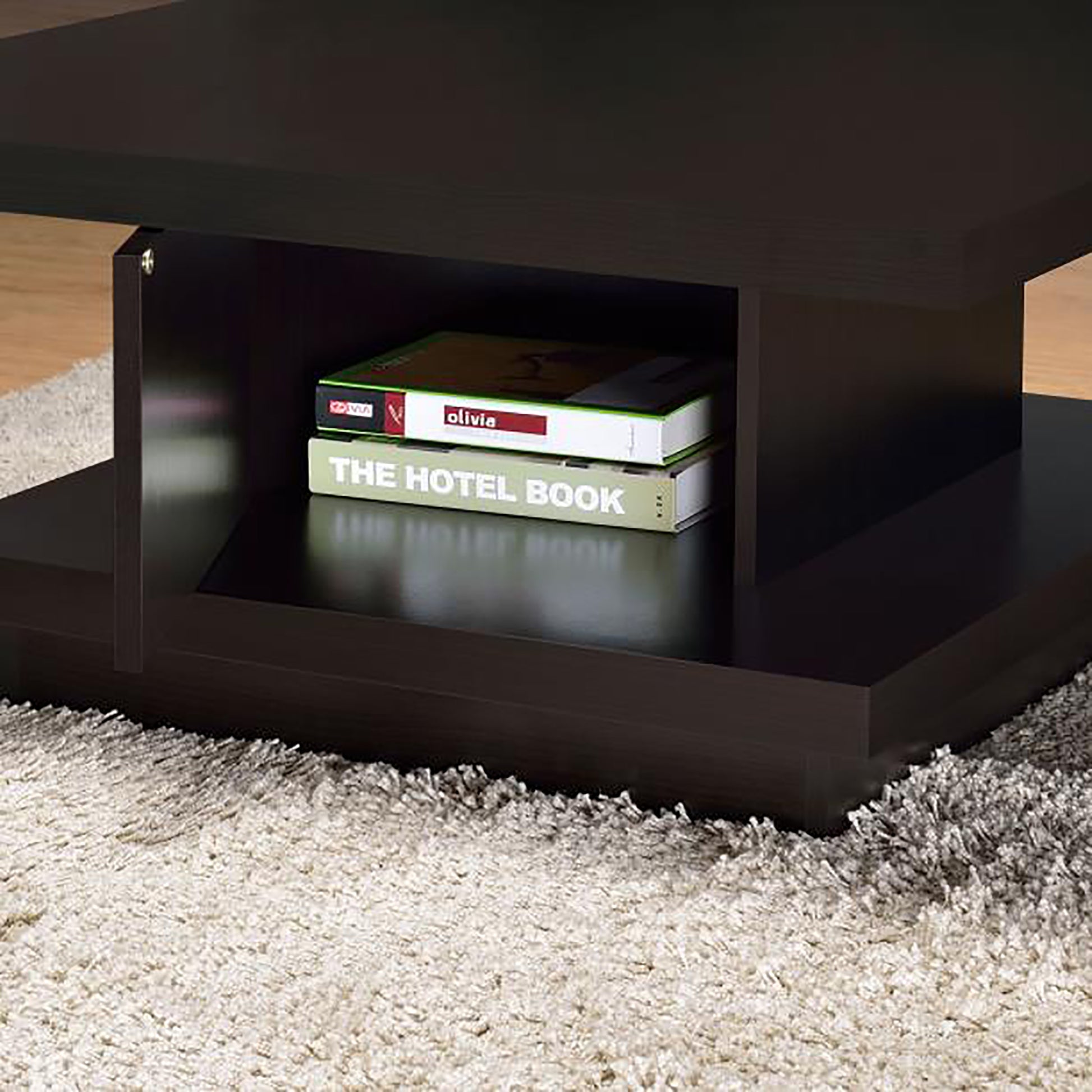 Dark brown wooden coffee table with open storage shelf holding books