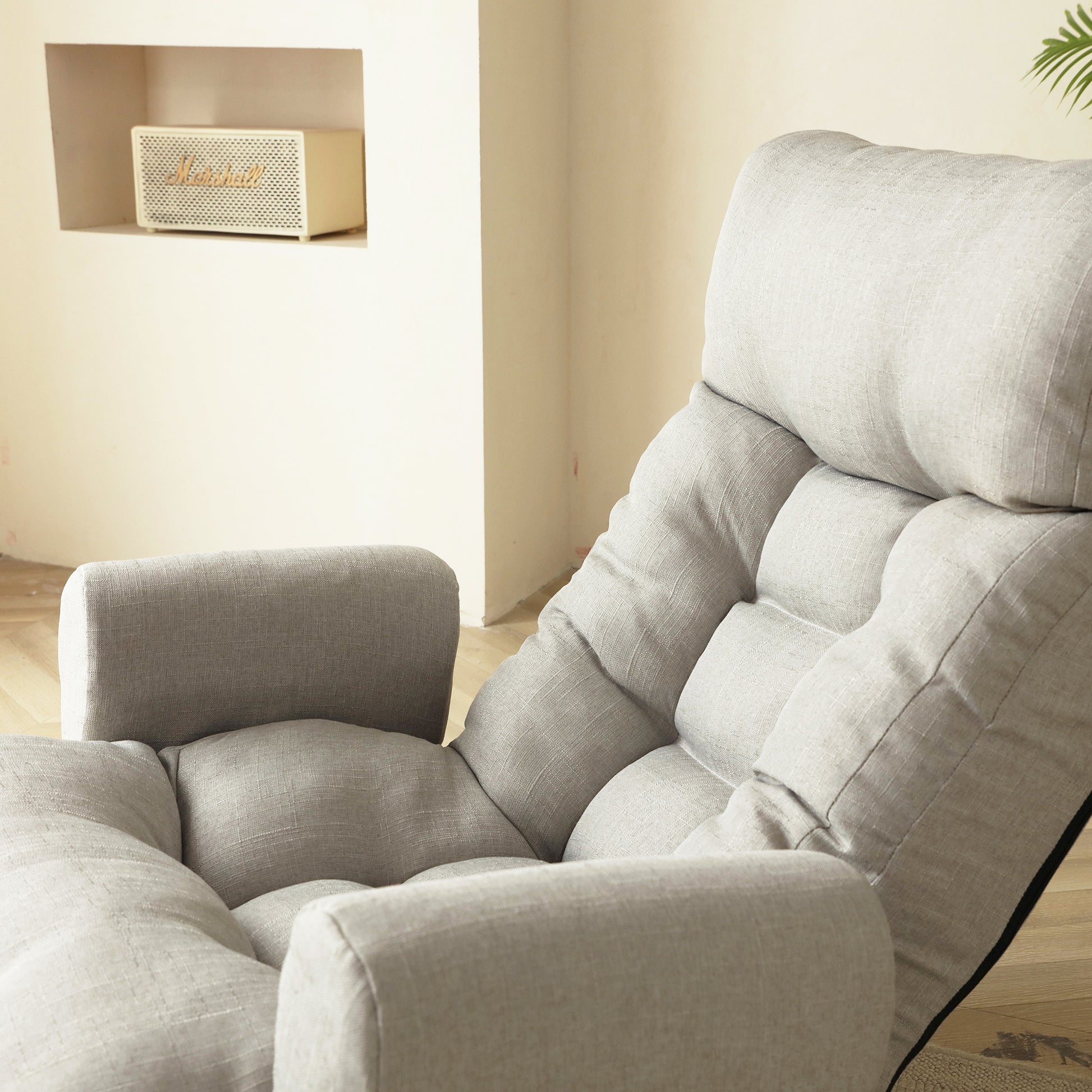 Light gray linen tufted floor chair with adjustable back and padded armrests for comfortable seating