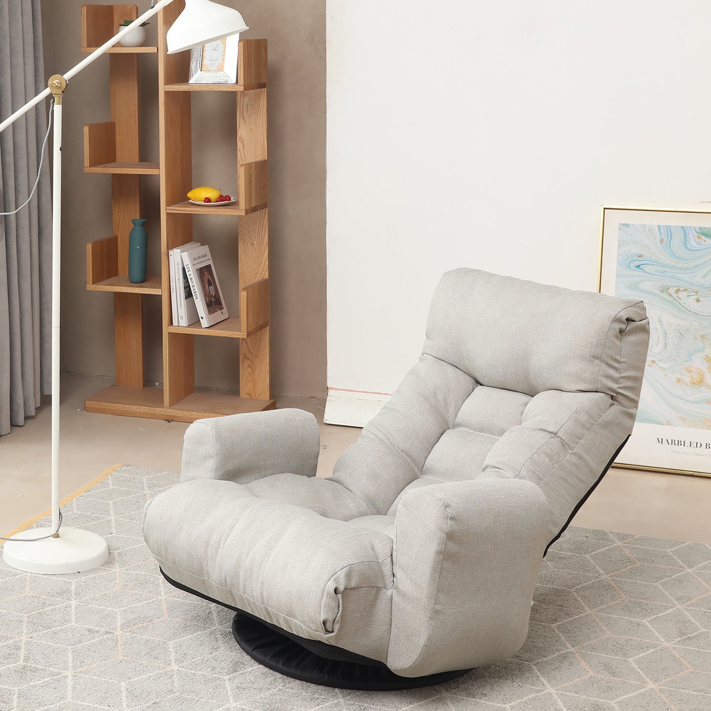 Light grey upholstered swivel floor chair with tufted cushions for comfortable lounging