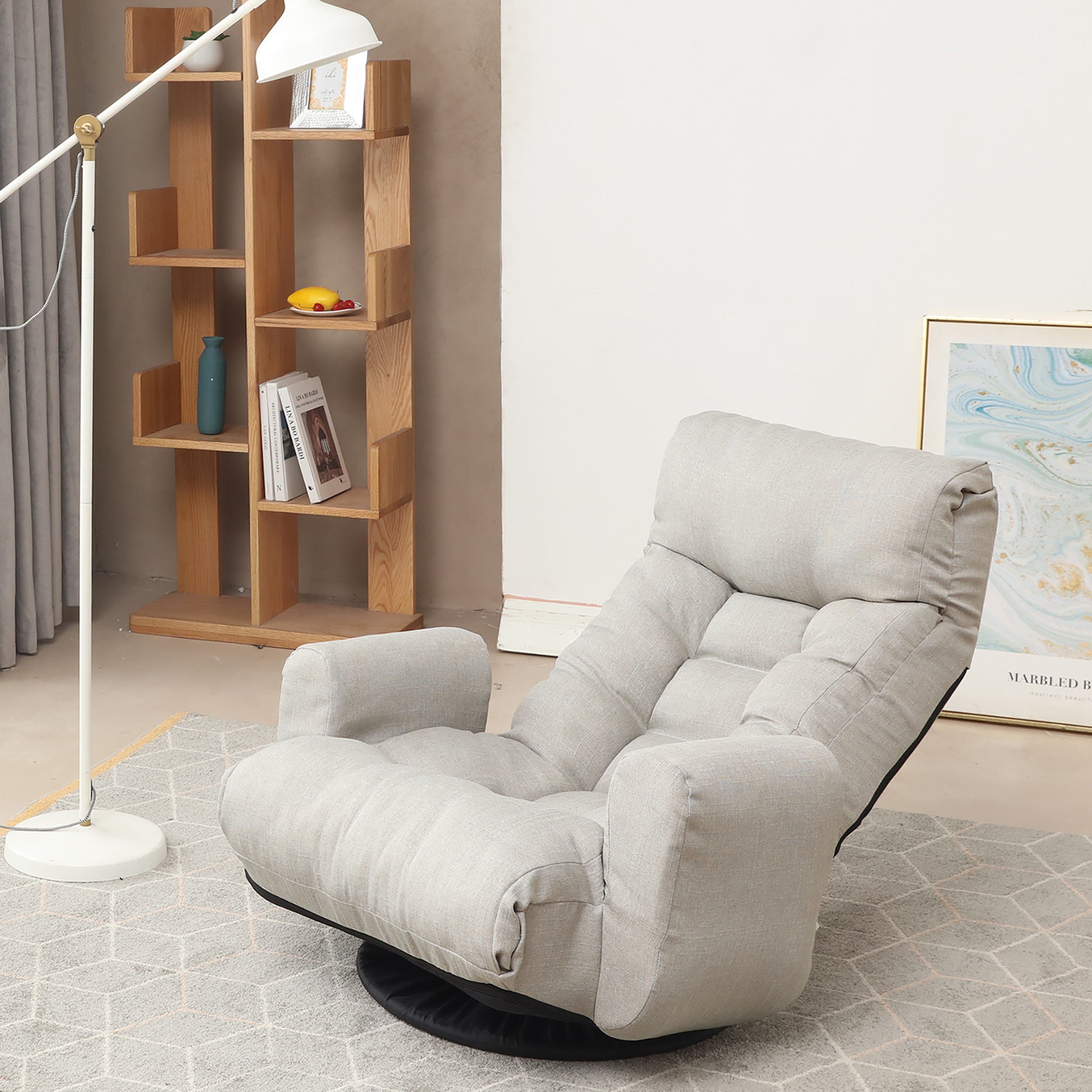 Light grey upholstered swivel floor chair with tufted cushions for comfortable lounging