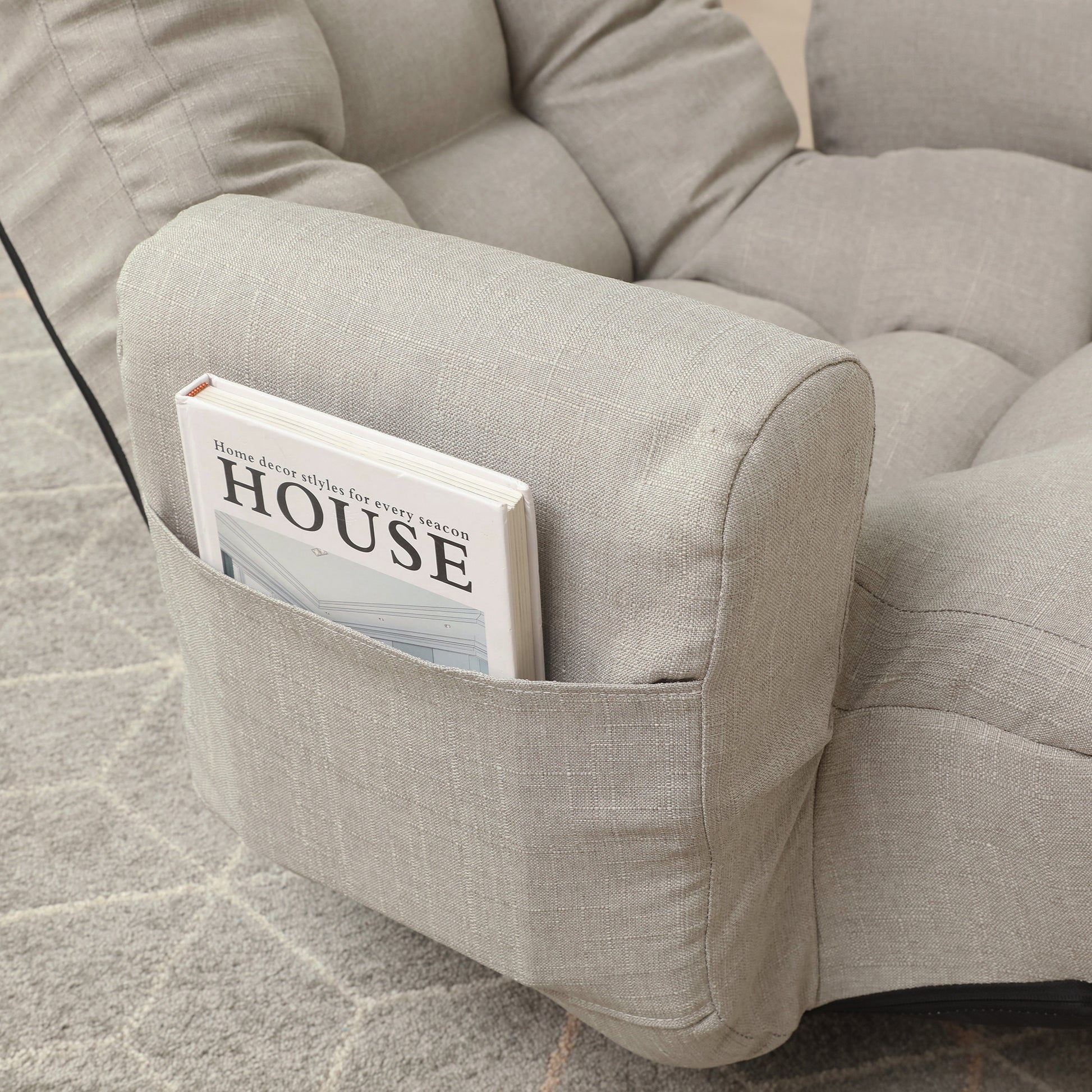 Light gray linen sofa armrest with builtin pocket holding a house decor magazine