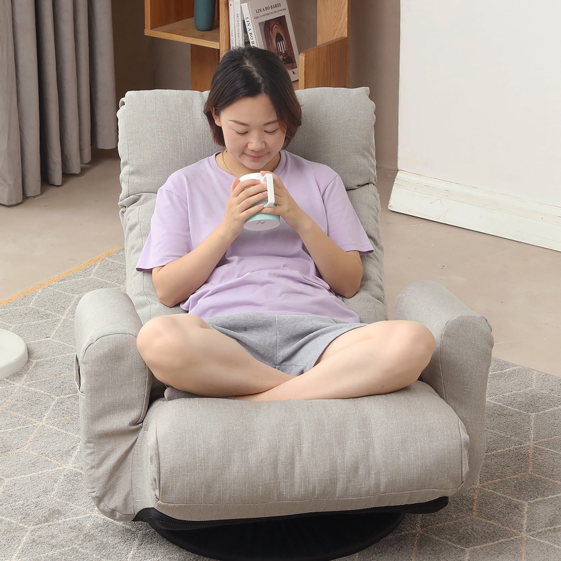 Grey linen swivel armchair with adjustable back for comfortable reading or relaxation