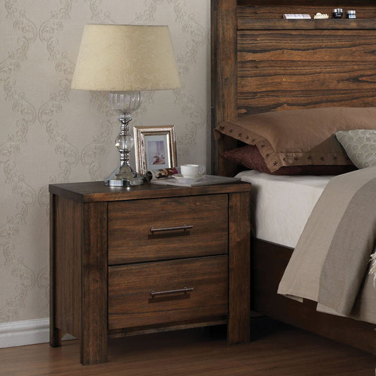 Dark wood nightstand with two drawers and silver handles holding a lamp