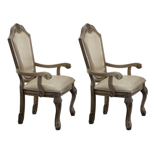 Pair of ornate carved wood dining chairs with upholstered cream seats and backs