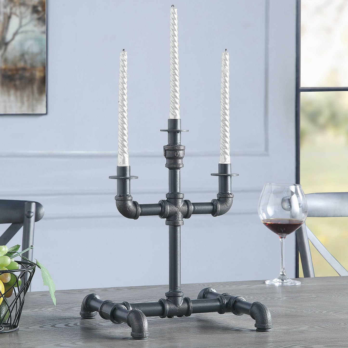 Black industrial pipe candelabra with three white twisted taper candles a statement piece