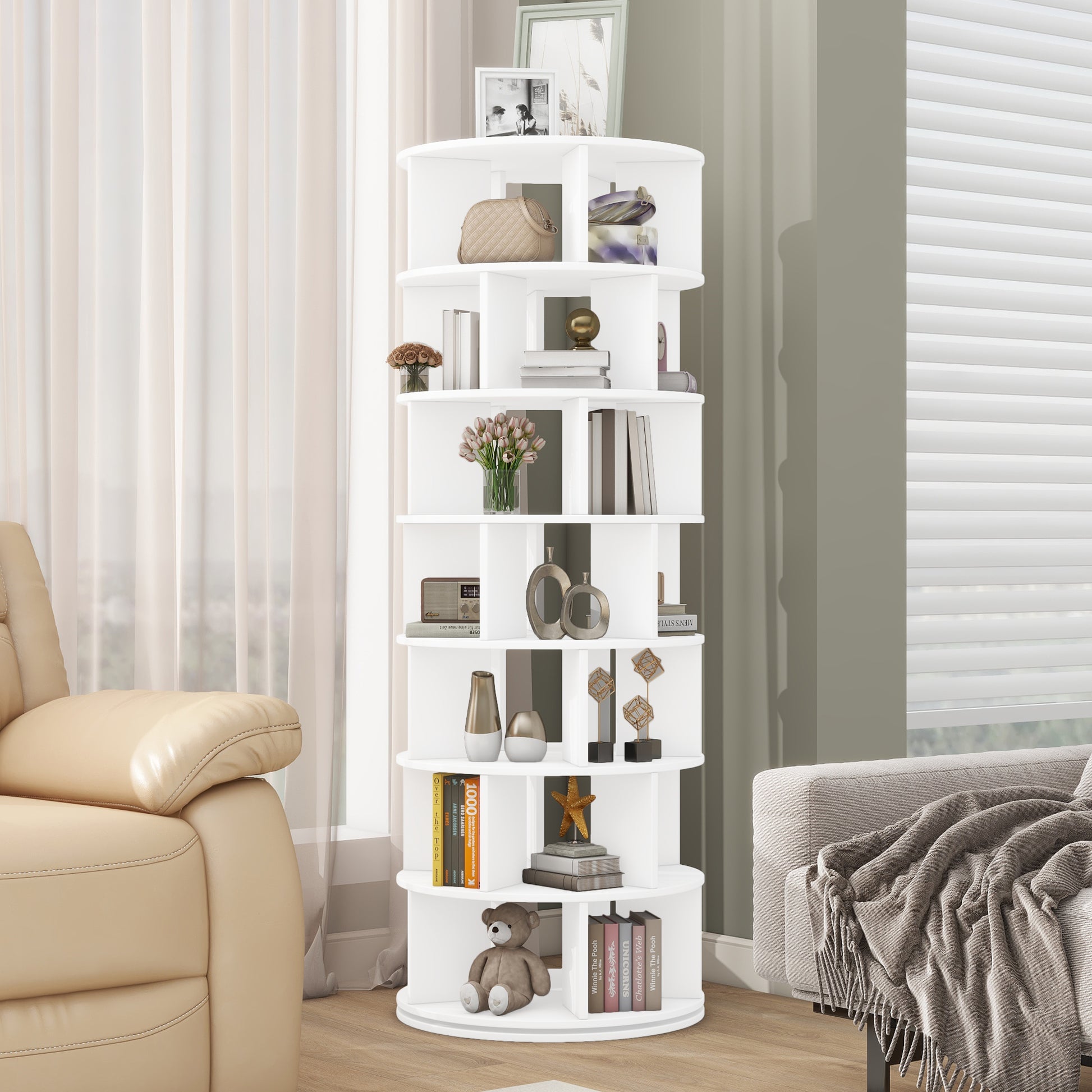 White rotating bookshelf with  tiers displaying books vases and decor