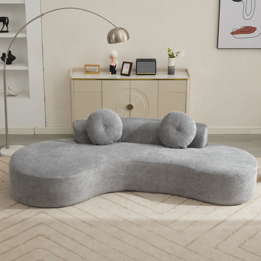 Gray curved sectional sofa with textured fabric and two round throw pillows