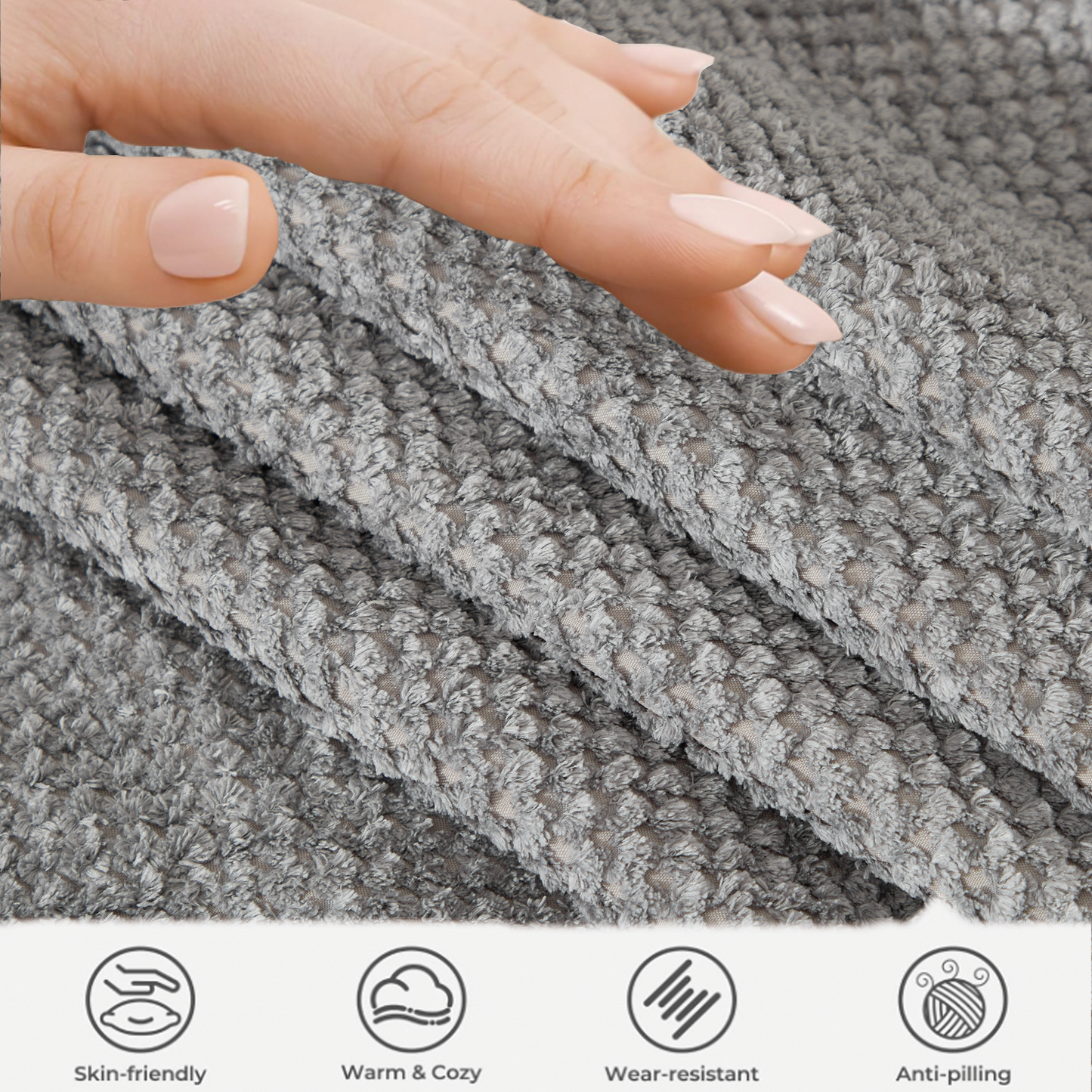 Closeup of soft grey textured plush fabric with a hand gently touching it highlighting its cozy feel