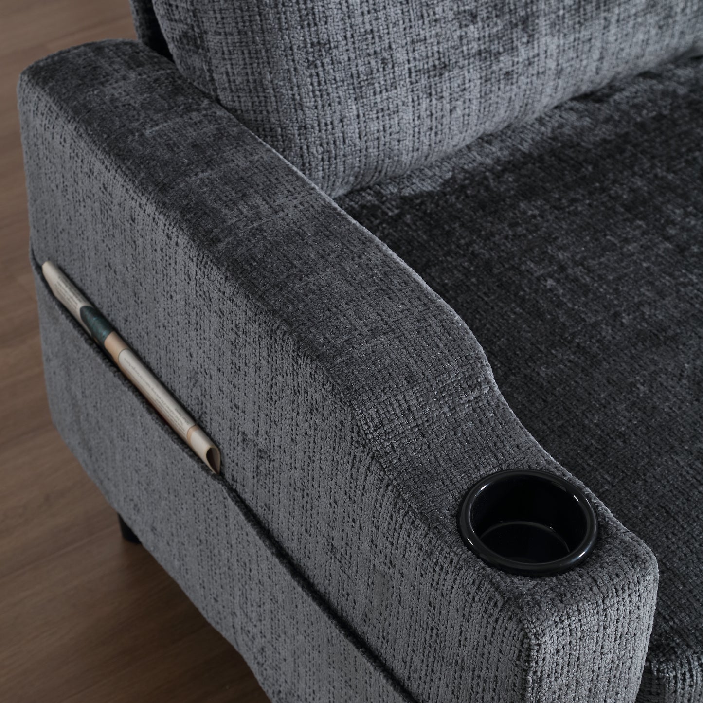 Dark grey recliner armrest with builtin cup holder and side pocket for magazines