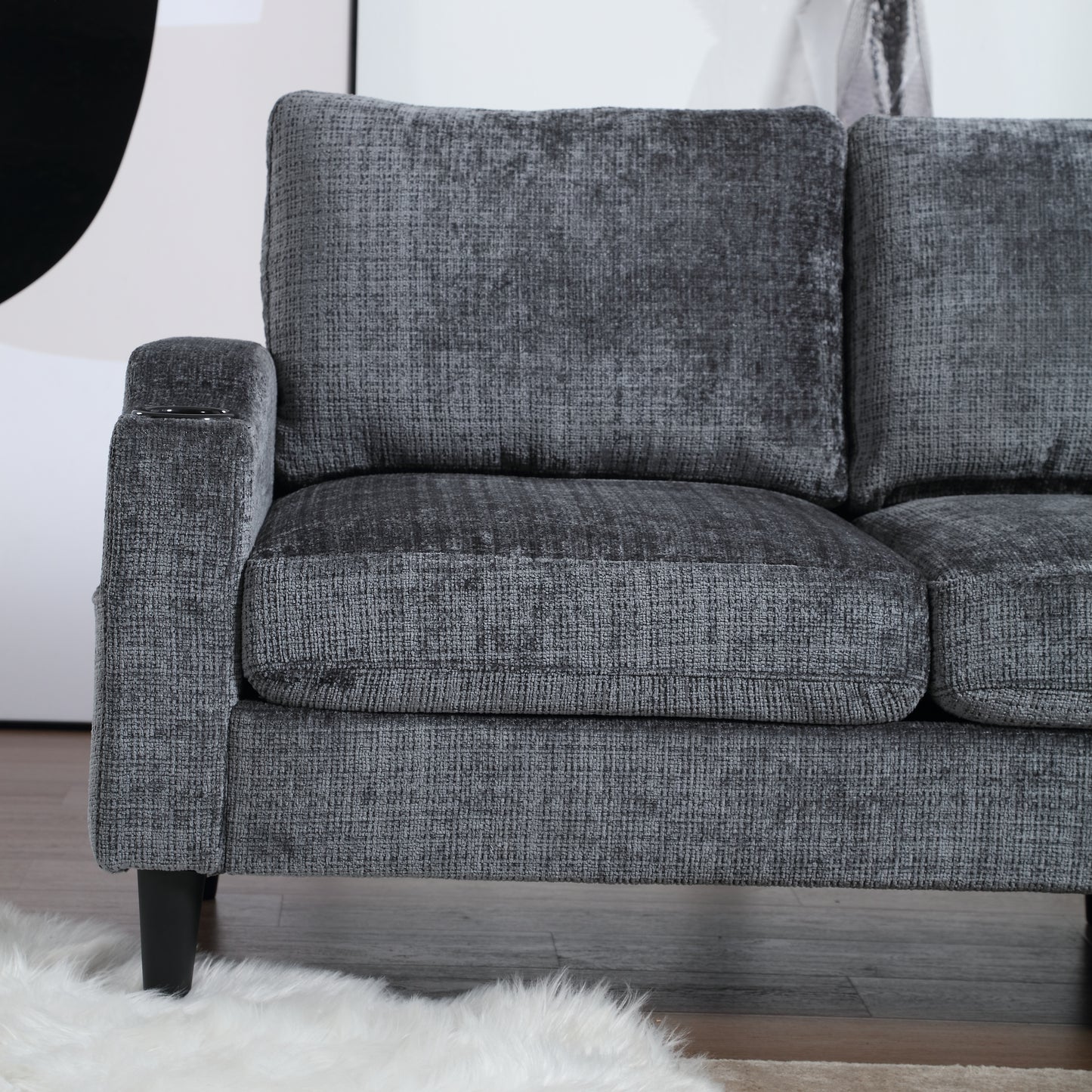 Plush grey fabric sofa with deep cushions and builtin cup holder on armrest perfect for a modern living room