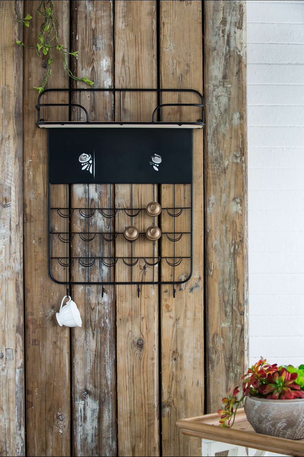 Black metal coffee pod organizer with shelf and hooks