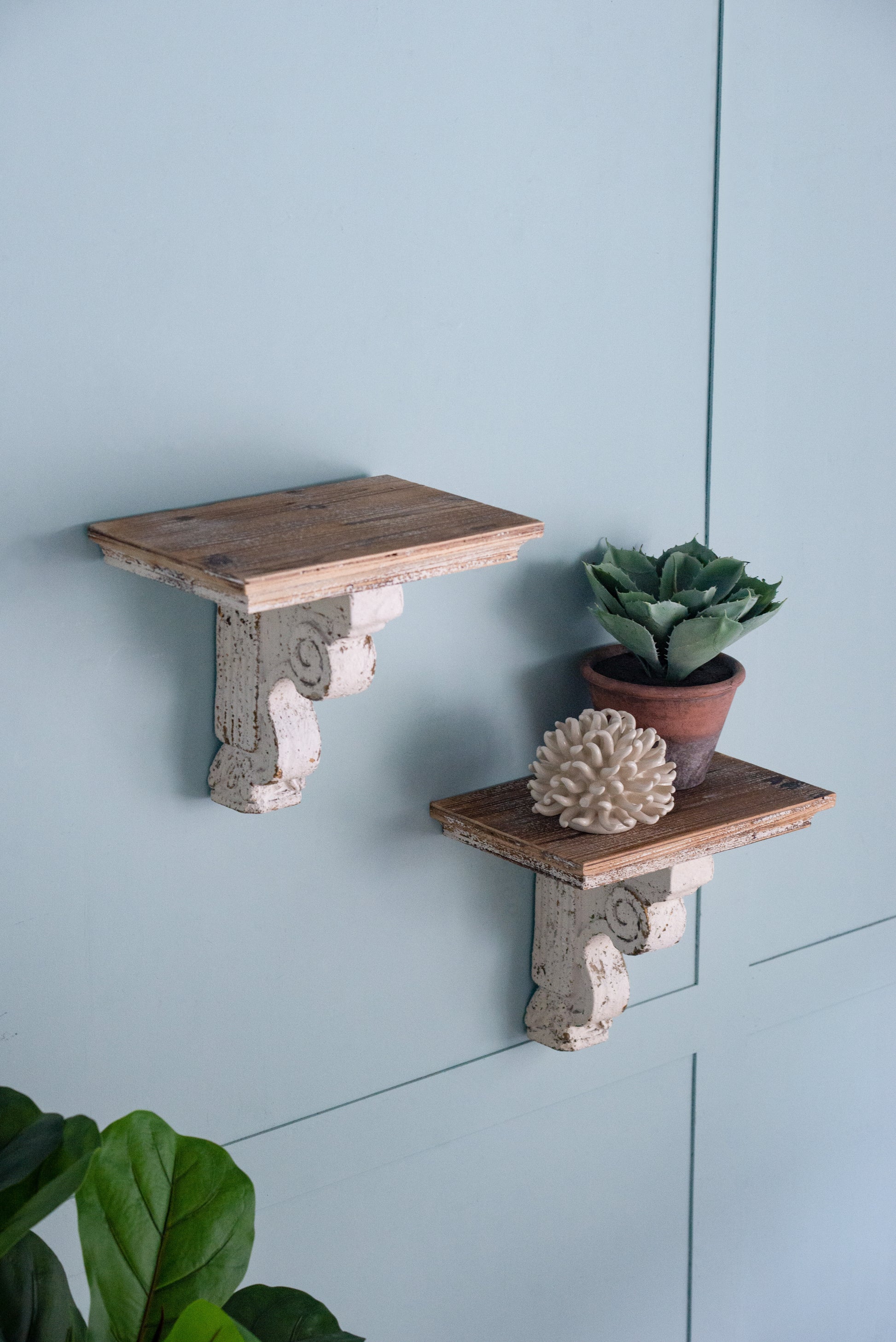 Rustic wooden wall shelf with distressed white corbel bracket for decorative display