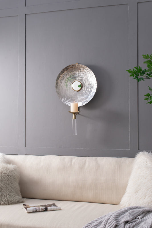 Hammered silver wall sconce with reflective centerpiece and cream candle