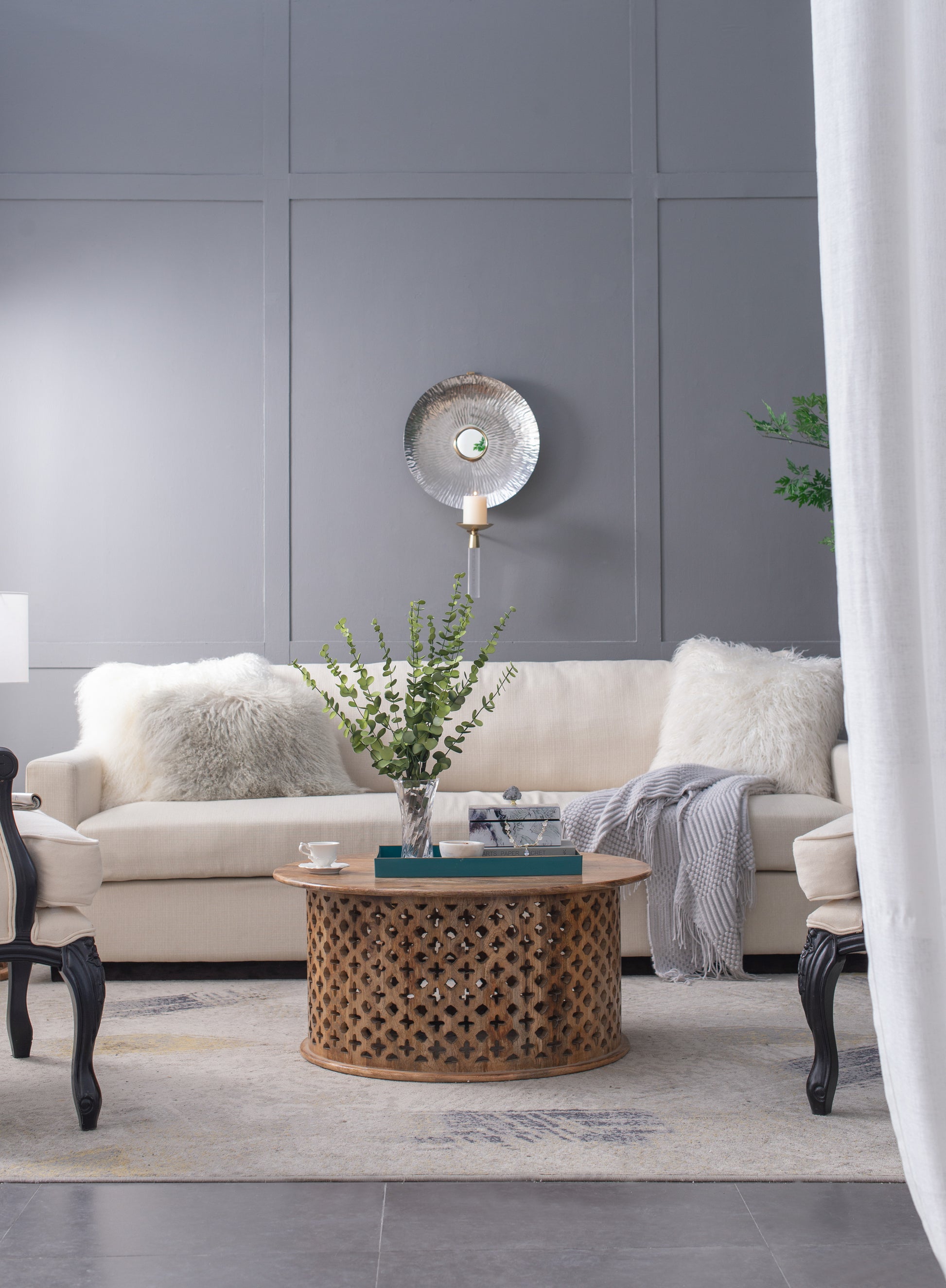 Cream sofa with two textured throws and fluffy pillows set for modern living room