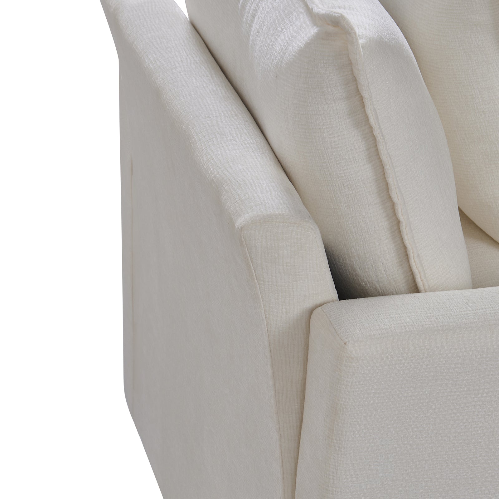 Closeup of a textured cream fabric sofa arm with plush cushions in the background