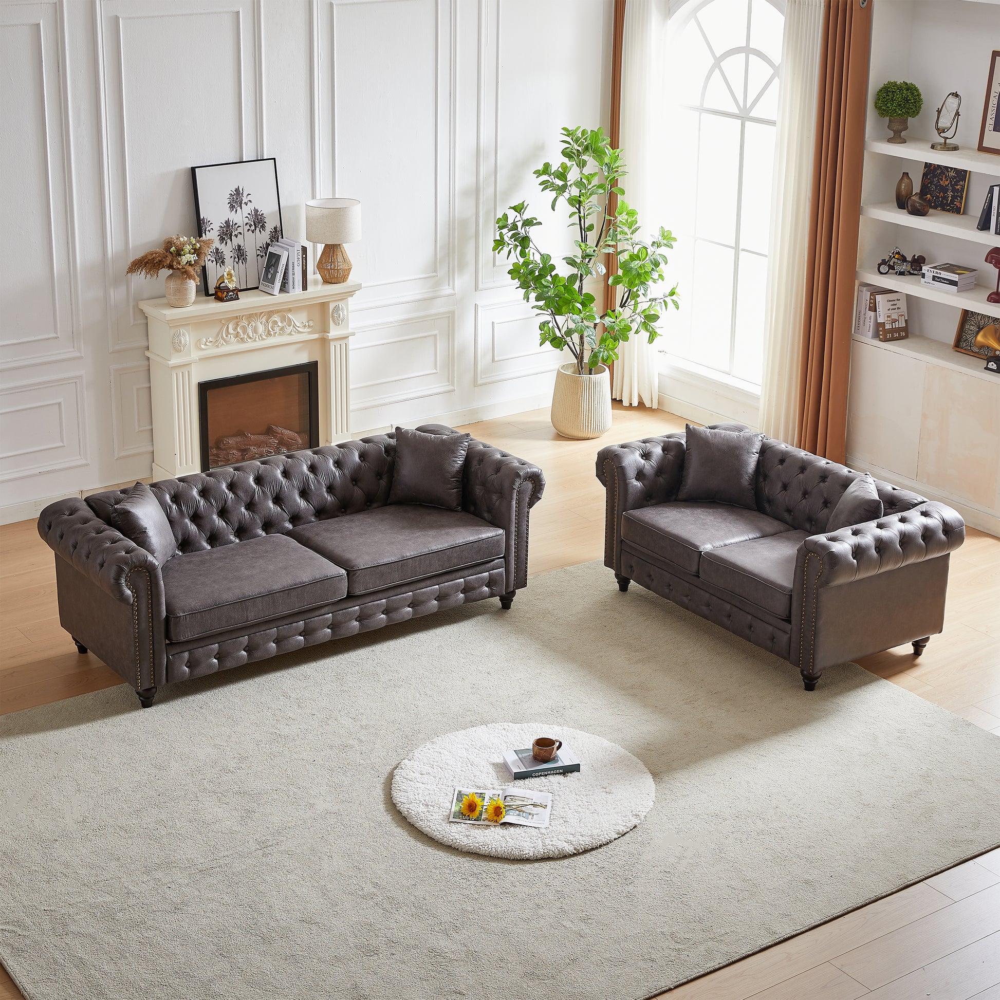 Dark gray tufted leather chesterfield sofa with nailhead trim in a formal living room setting