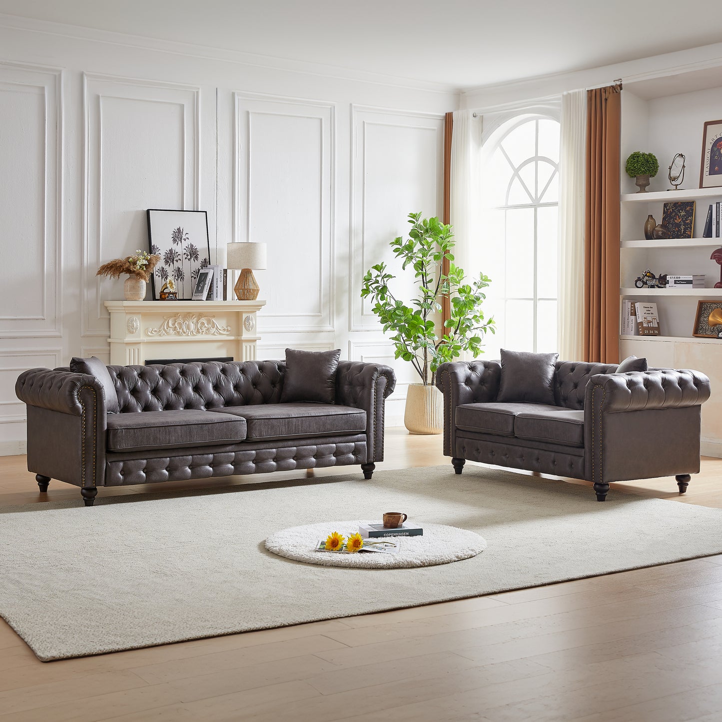 Dark gray tufted leather Chesterfield sofa with nailhead trim and plush cushions