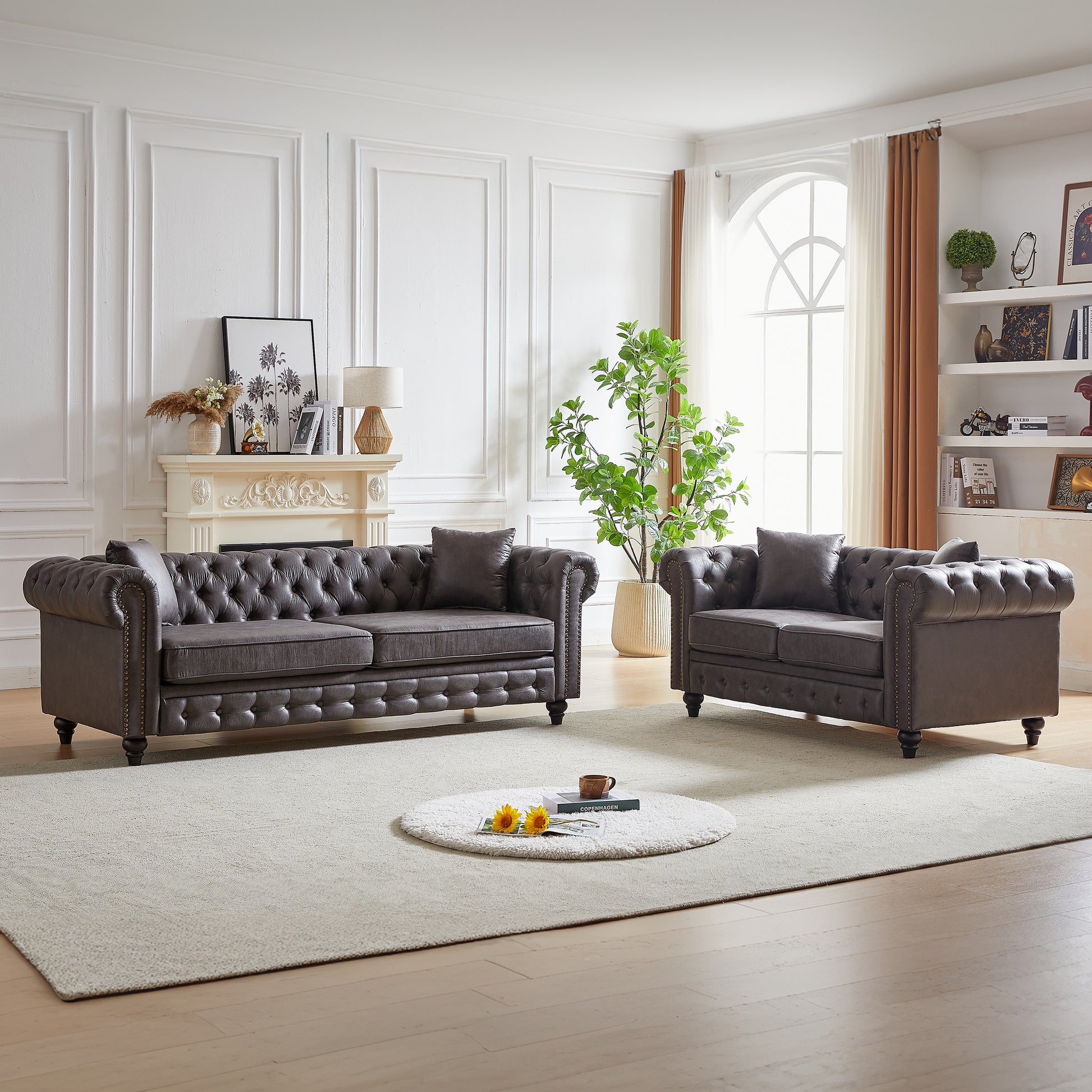 Dark gray tufted leather Chesterfield sofa with nailhead trim and plush cushions