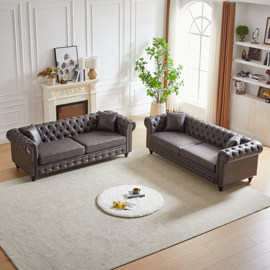 Dark gray tufted leather Chesterfield sofa with rolled arms and nailhead trim
