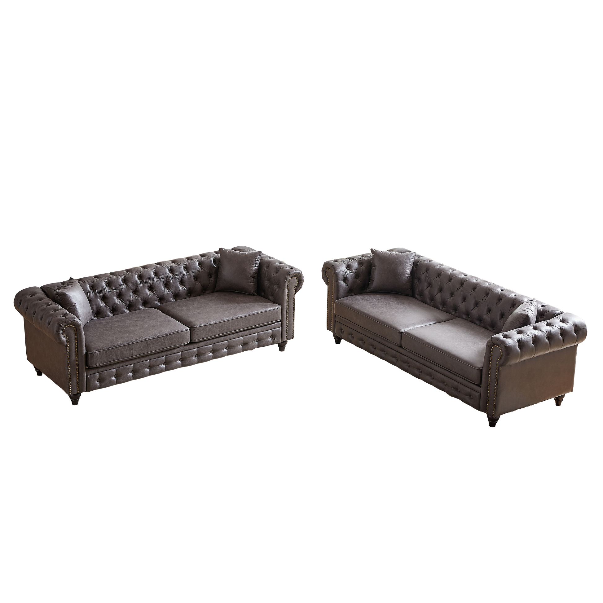 Dark gray leather chesterfield sofa with deep button tufting and brass nailhead trim
