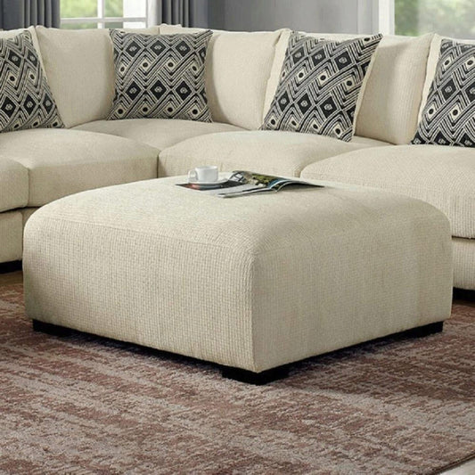 Cream textured fabric ottoman with a magazine and cup on top perfect for living room decor