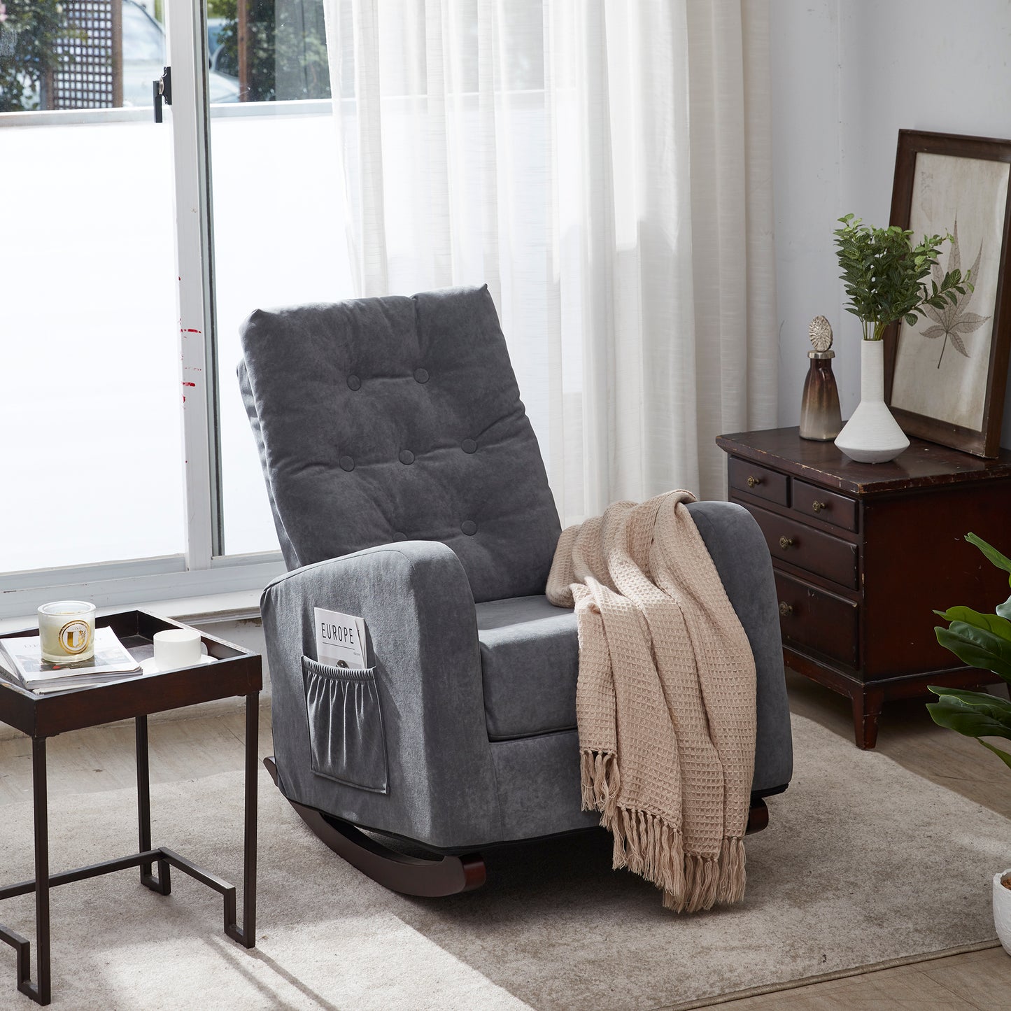 Tufted dark gray fabric recliner rocking chair with side pockets holding magazines