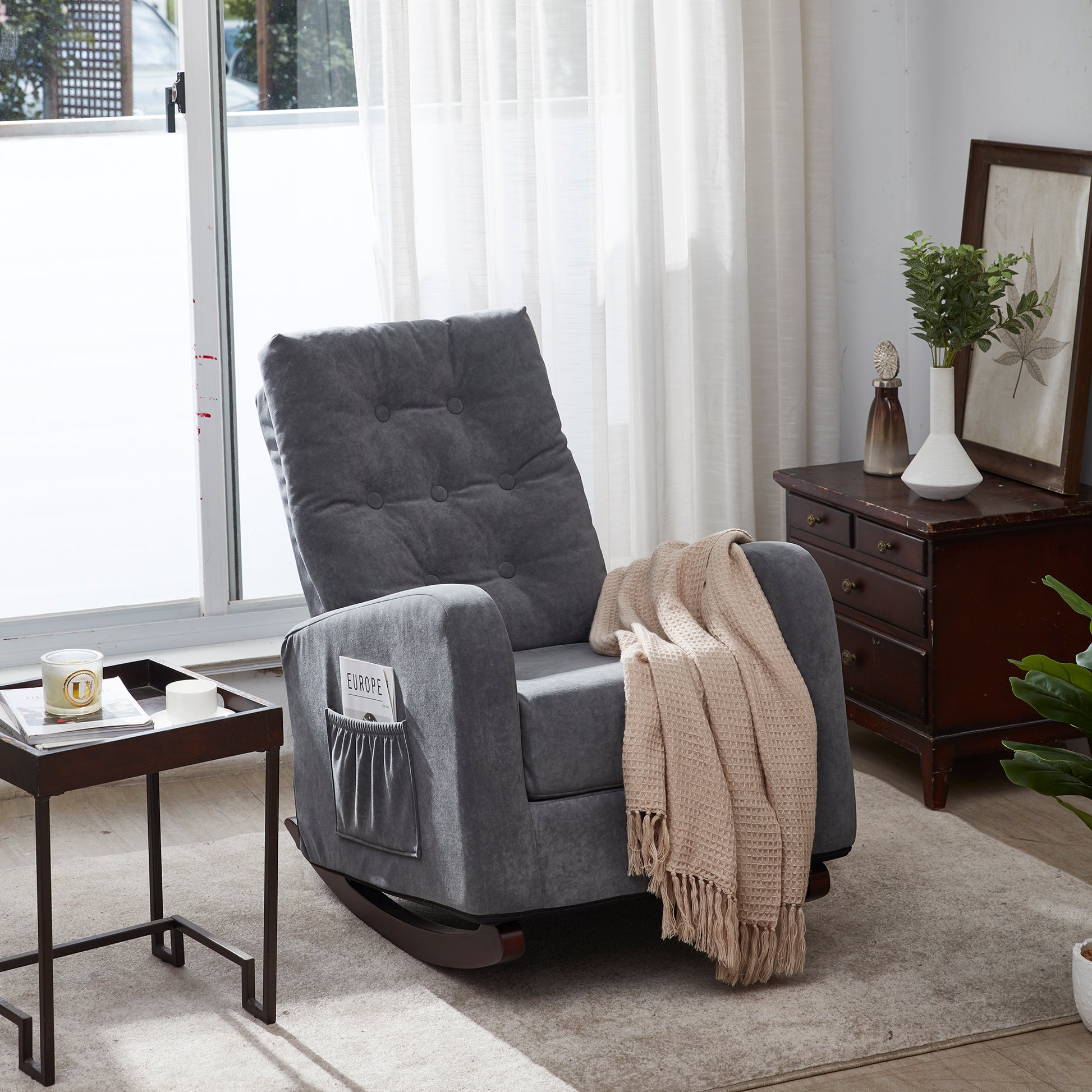 Tufted dark gray fabric recliner rocking chair with side pockets holding magazines