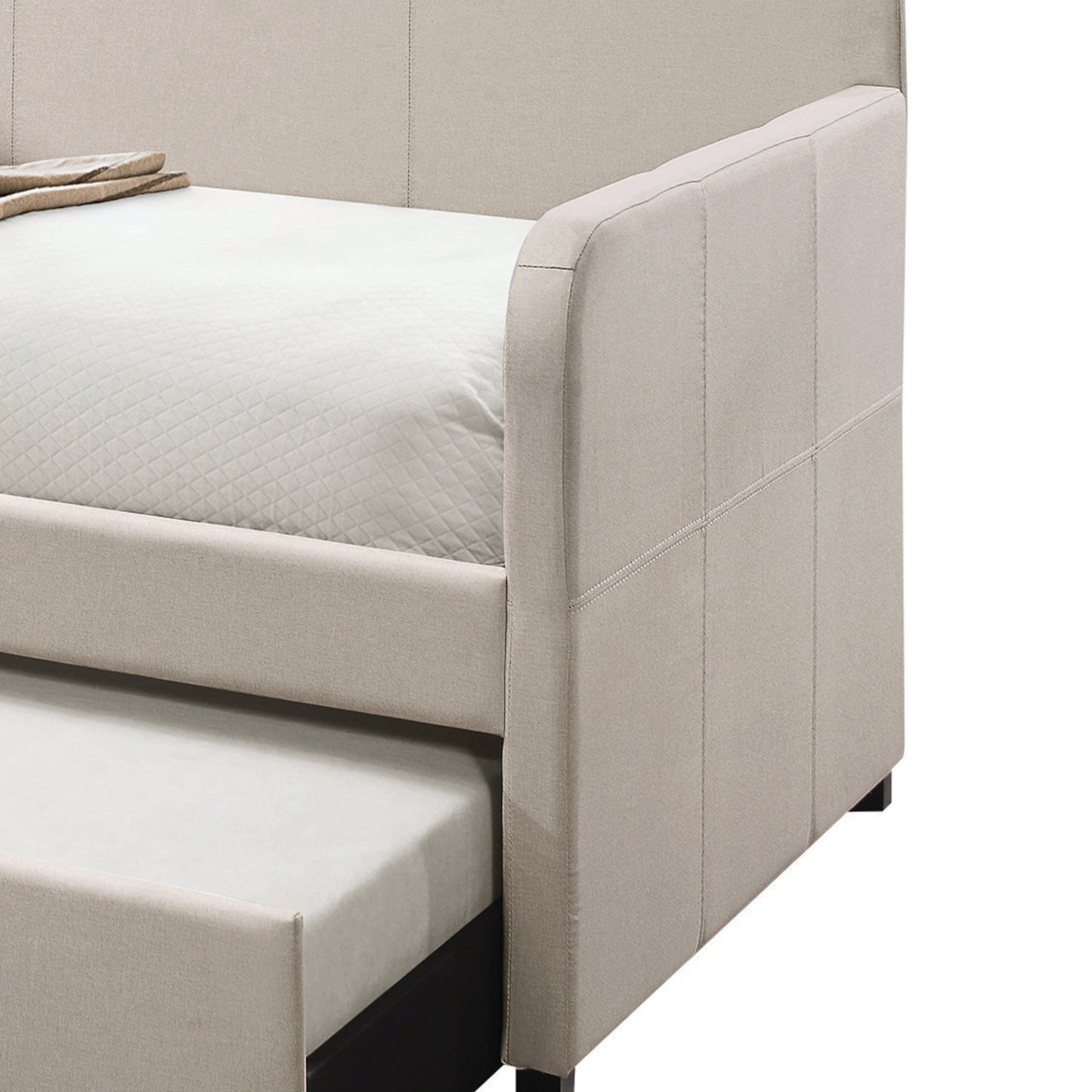 Beige upholstered daybed with a pullout trundle bed quilted mattress