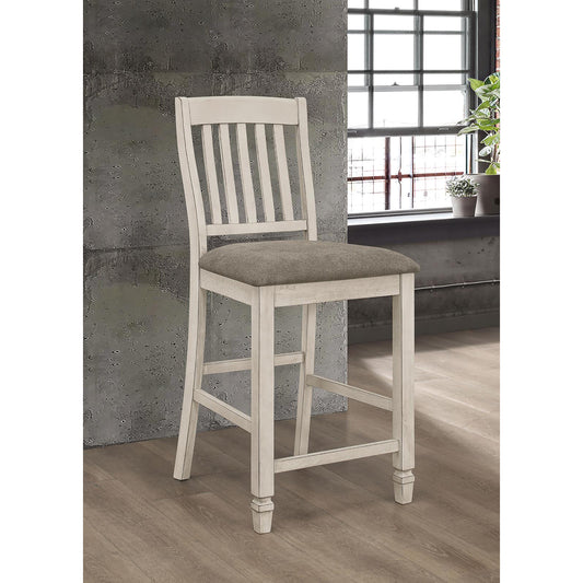 Distressed white wood bar stool with a gray upholstered seat and slatted back