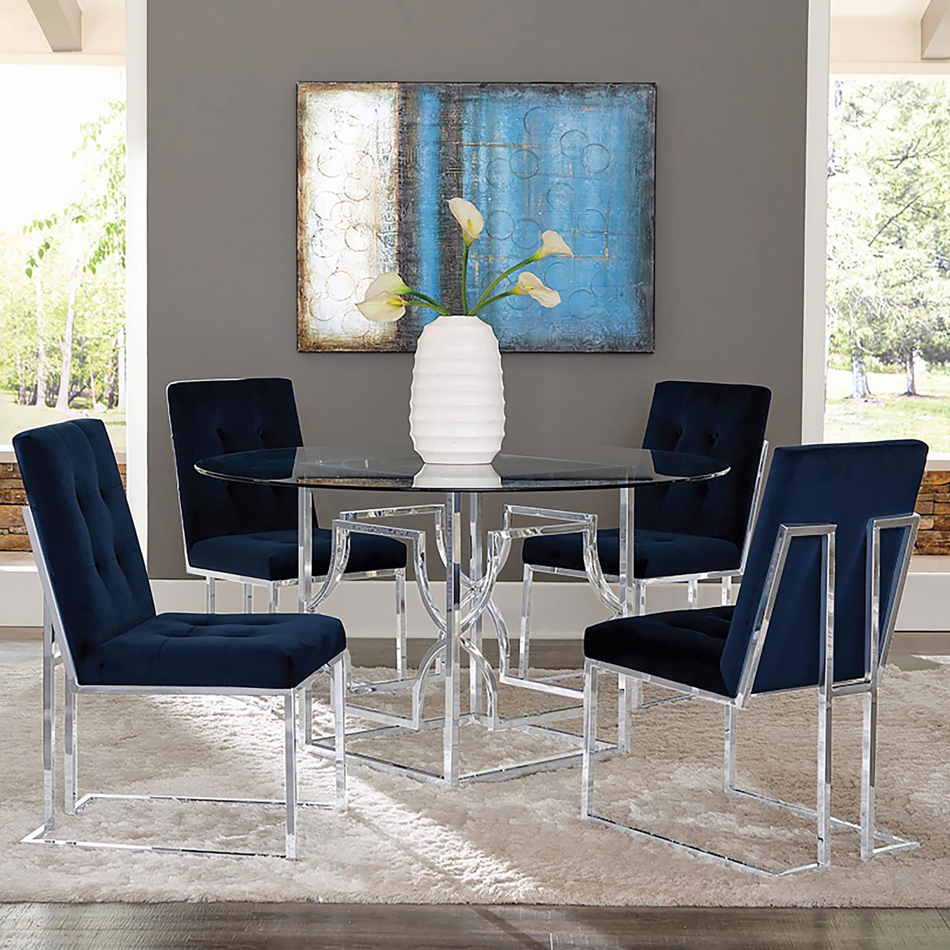 Tufted navy velvet dining chairs with chrome frames surrounding a glasstop table