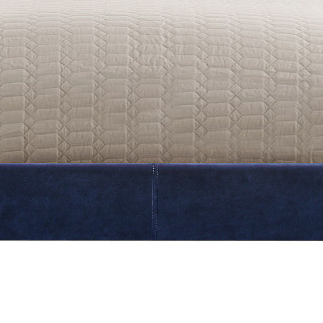 Deep navy blue velvet bed frame with textured beige comforter