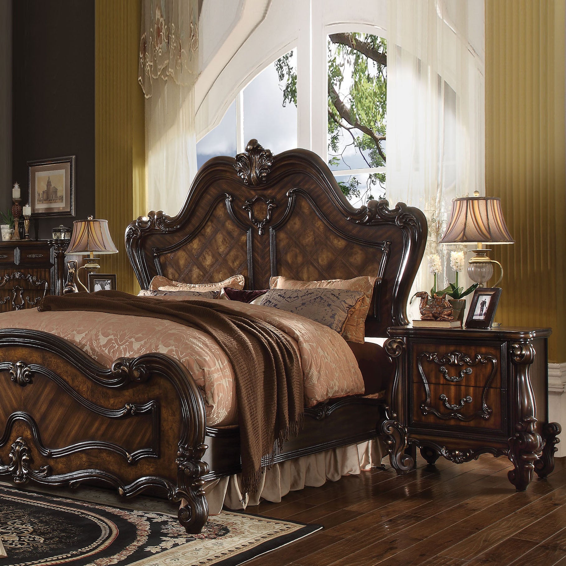 Ornate dark wood ornate bed with diamond tufted headboard and plush bedding