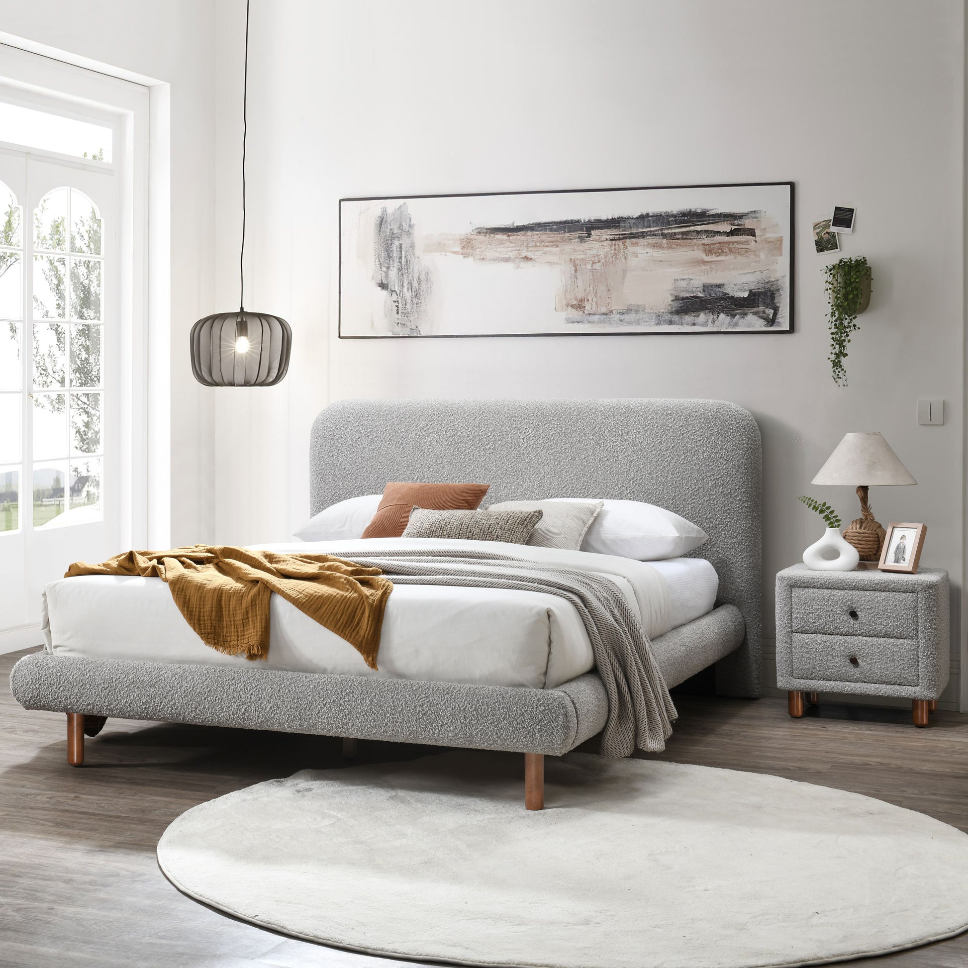 Textured grey boucle fabric bed frame with wooden legs and mustard throw