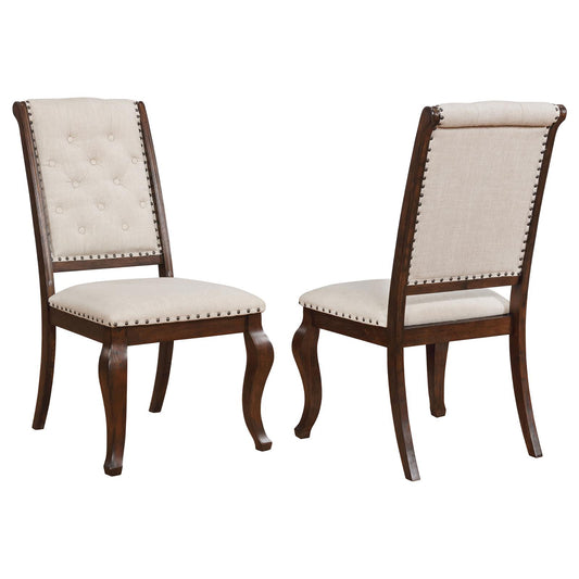 Tufted beige fabric dining chair with dark wood frame and nailhead trim