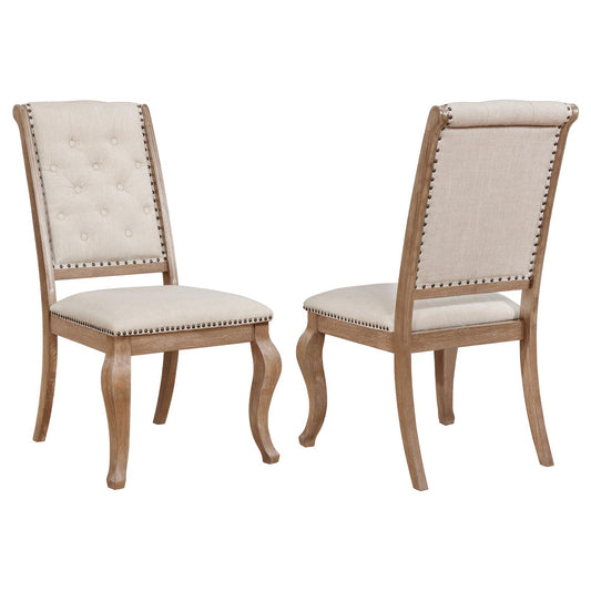 Tufted beige fabric dining chair with nailhead trim and curved wooden legs