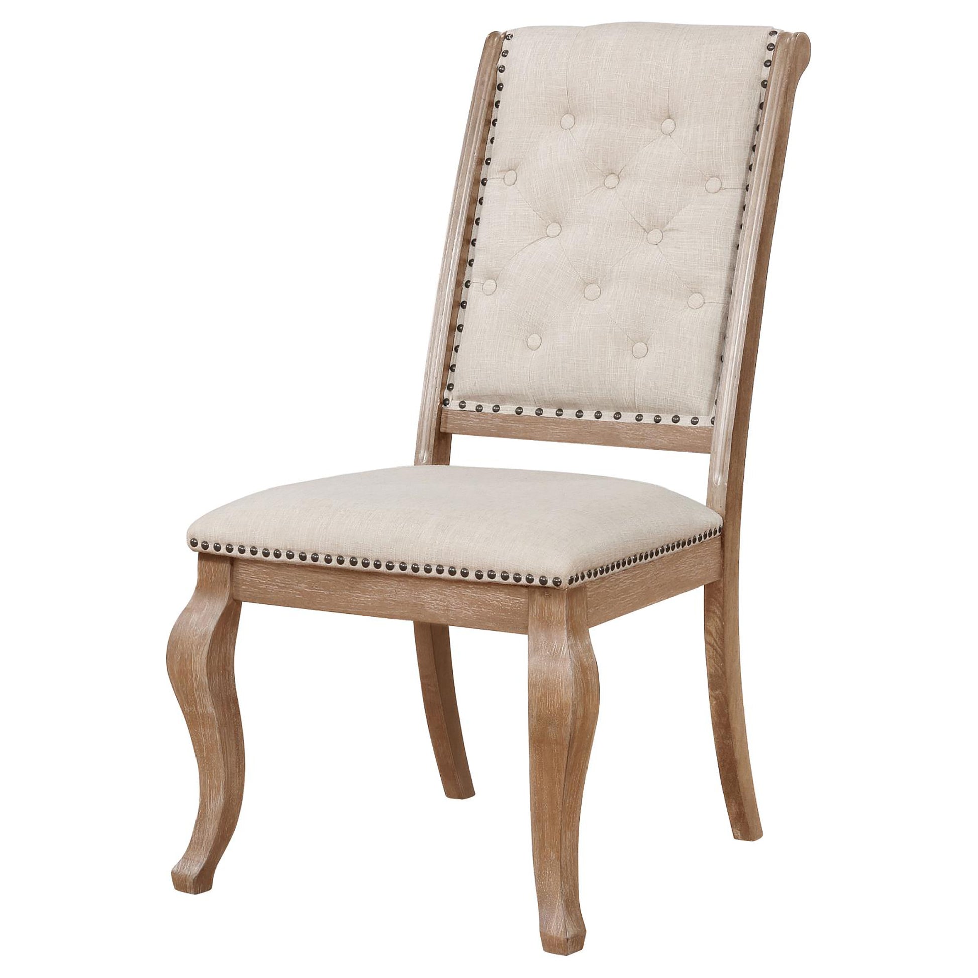 Tufted natural linen dining chair with ornate carved wood legs and brass nailhead trim